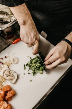 a cook slicing vegetables on a cutting board